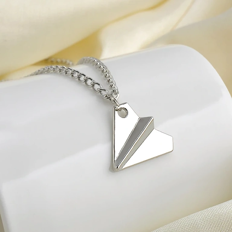Silver airplane-shaped pendant worn by Harry Styles from One Direction